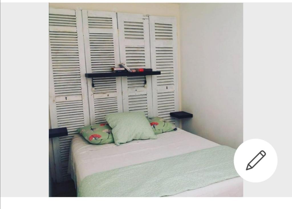 um pequeno quarto com uma cama com duas almofadas em La Tonnelière em Marseillan