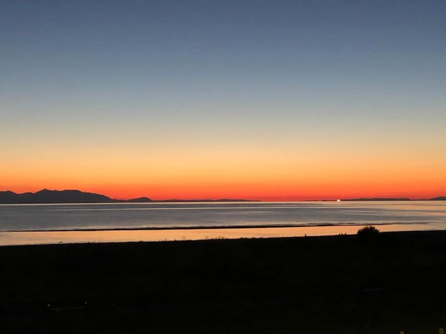 a sunset over a large body of water at Creathie Cathcart - Georgian Luxury at the beach in Ayr