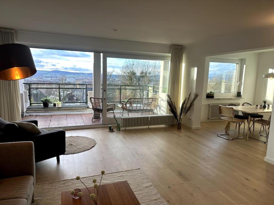 uma sala de estar com uma mesa e uma grande janela em Ruhiges Penthouse mit Weitblick em Göttingen