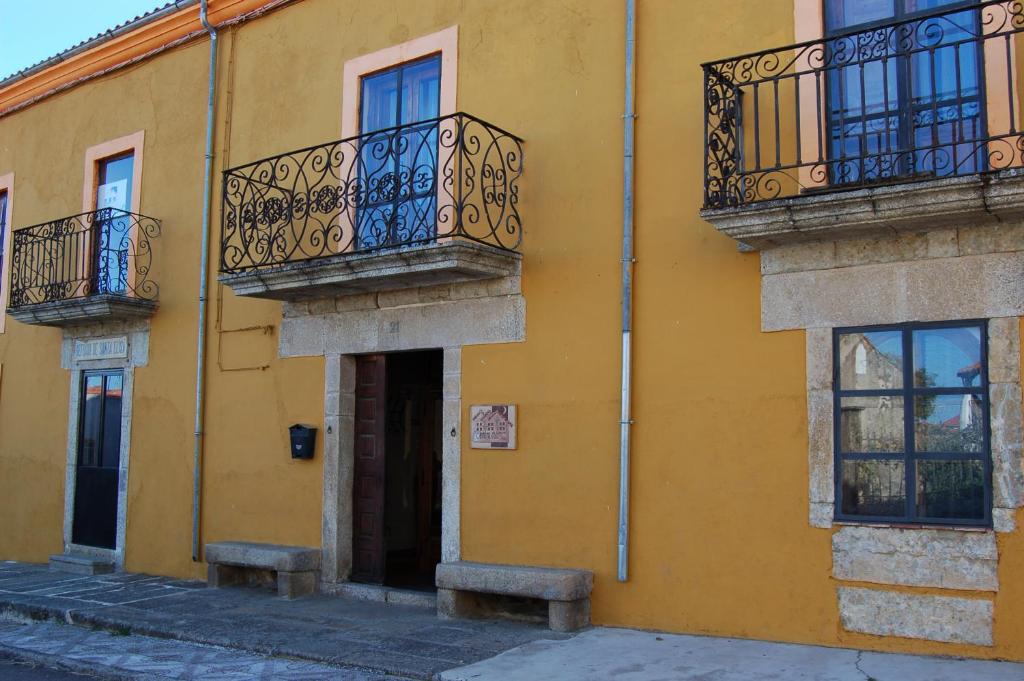 un edificio amarillo con balcones en una calle en CTR. El Convento, en El Bodón