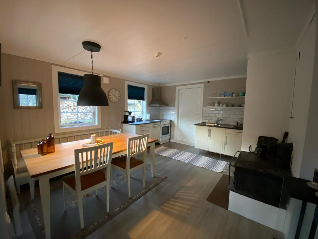 a kitchen with a wooden table and chairs in it at Rabben in Årjäng