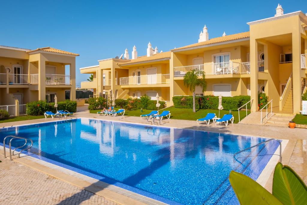 a swimming pool in front of a villa at Jardins Vale de Parra in Albufeira