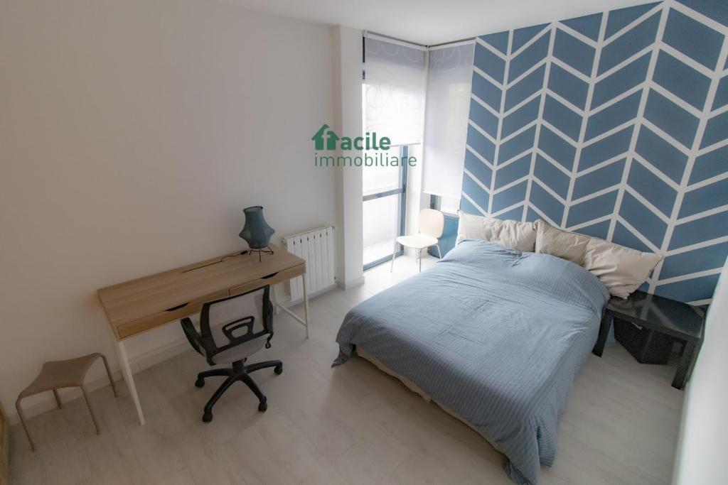 una camera con letto, scrivania e di WELCOME HOME - CAMERA privata in Appartamento Condiviso a RHO a Rho
