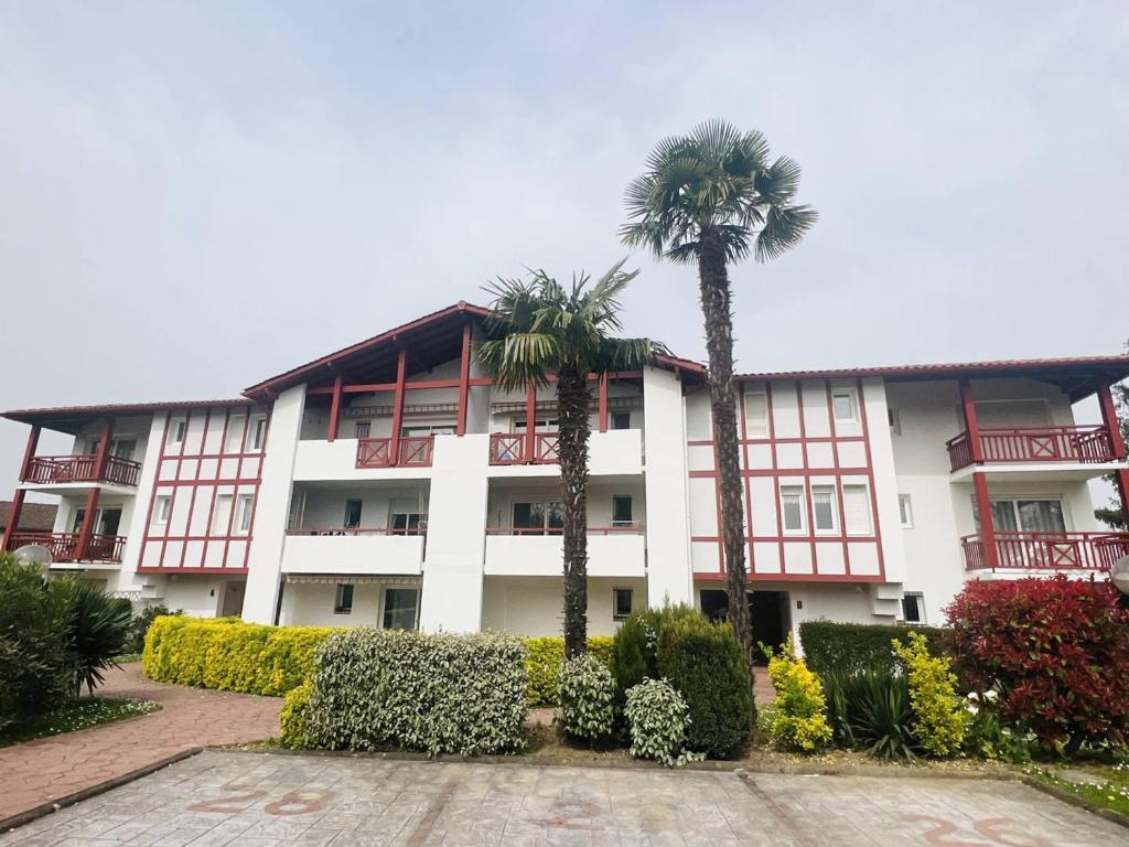 a building with two palm trees in front of it at Appartement Cambo-les-Bains, 1 pièce, 2 personnes - FR-1-495-16 in Cambo-les-Bains