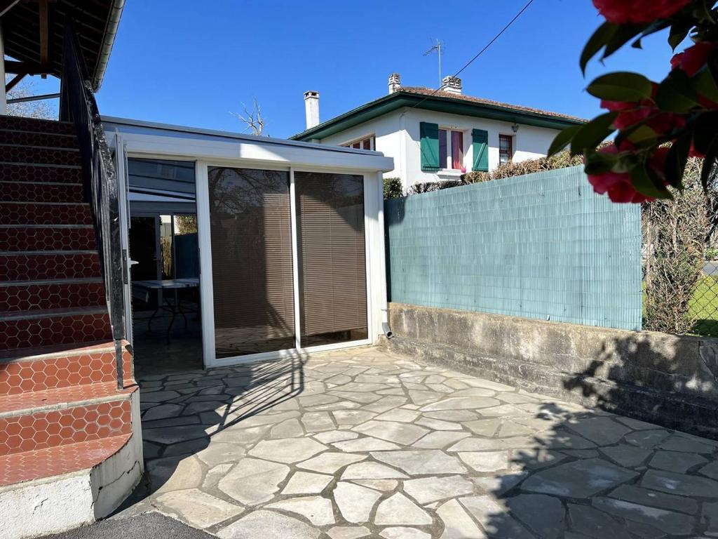 un patio de una casa con una puerta corredera de cristal en Appartement Cambo-les-Bains, 2 pièces, 2 personnes - FR-1-495-93, en Cambo-les-Bains