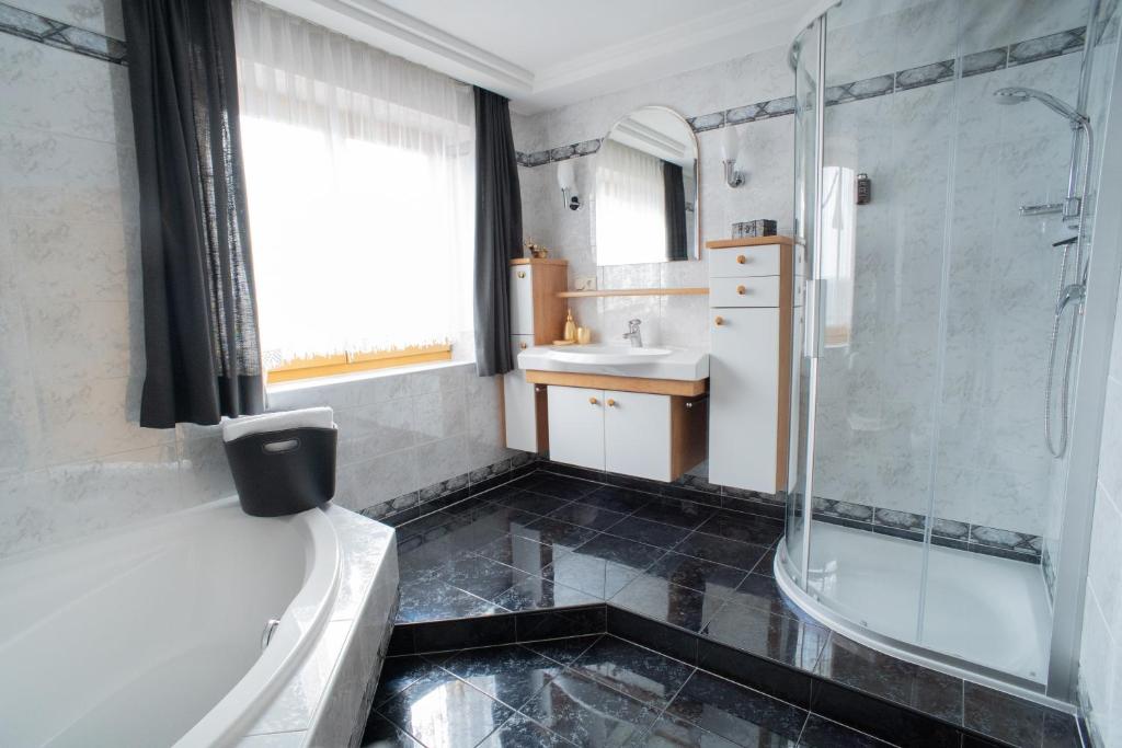 a bathroom with a tub and a sink and a shower at Landhaus Anita Dolomiten Kronplatz in Perca