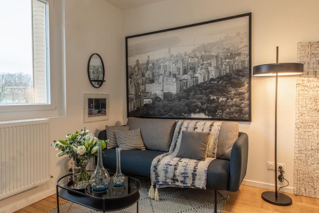 a living room with a couch and a painting on the wall at DIFY Industriel - Parilly in Vénissieux