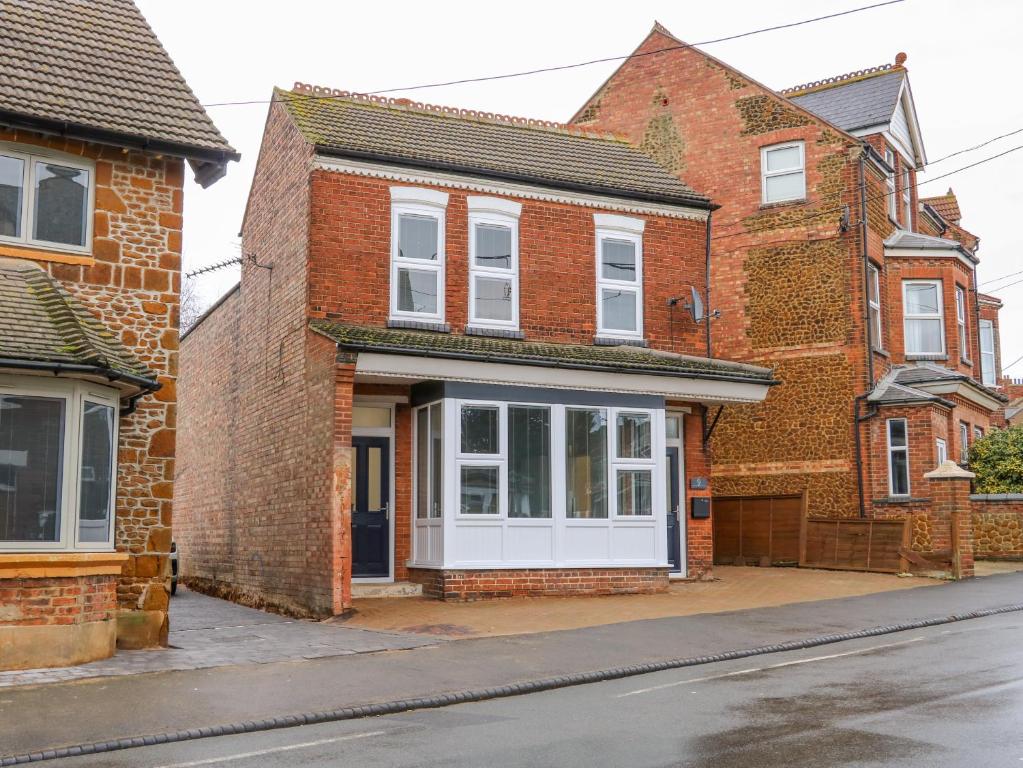 a brick house with a white door on a street at Sea Breeze Apartment No 7 in Hunstanton