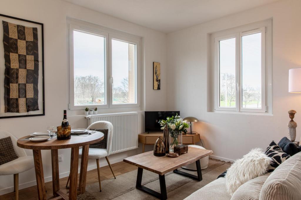 sala de estar con mesa y sofá en DIFY Chalet a la ville - Parilly, en Vénissieux
