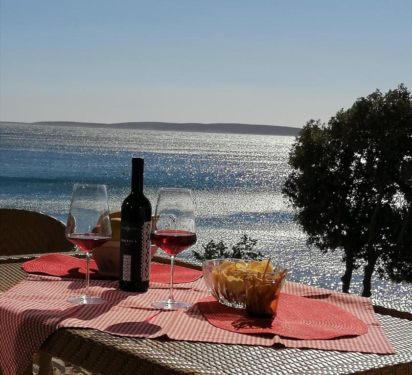 a table with two wine glasses and a bottle of wine at Bella Mare in Mandre