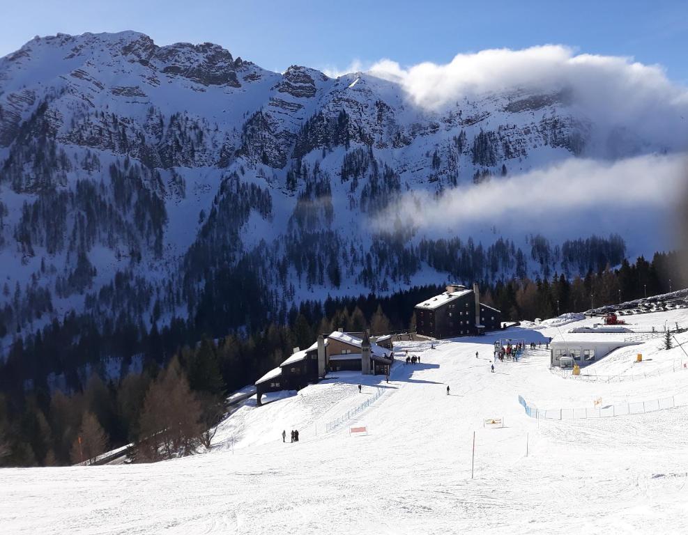 a snow covered mountain with a ski lodge on a ski slope at La Casa degli Gnomi in Falcade