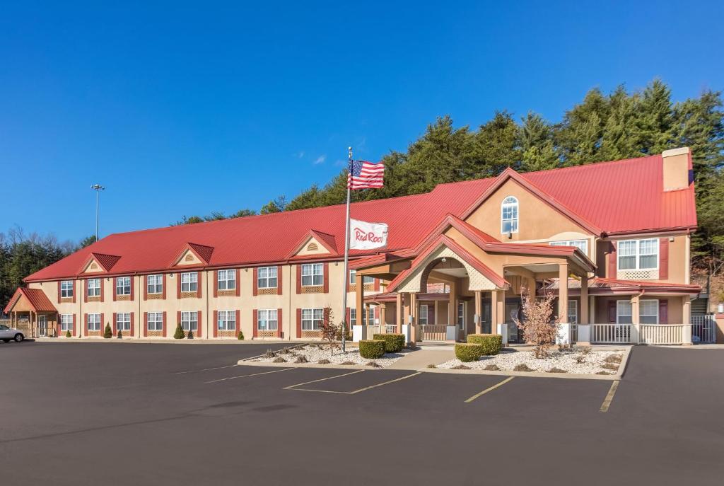 un hotel con bandera americana en un estacionamiento en Red Roof Inn & Suites Corbin, en Corbin