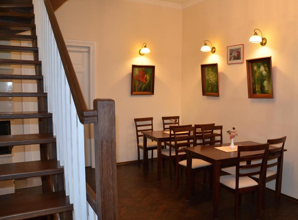 a dining room with tables and chairs and a staircase at Hotel MP in Lviv