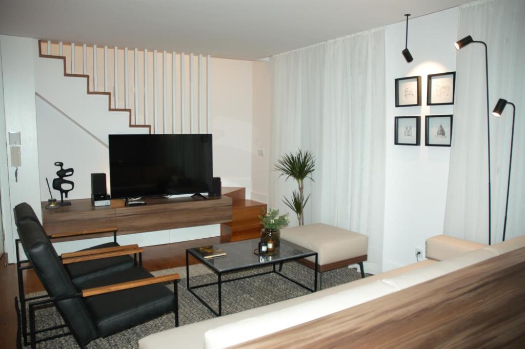 a living room with a television and a chair at Timeless Charming - Belém in Lisbon