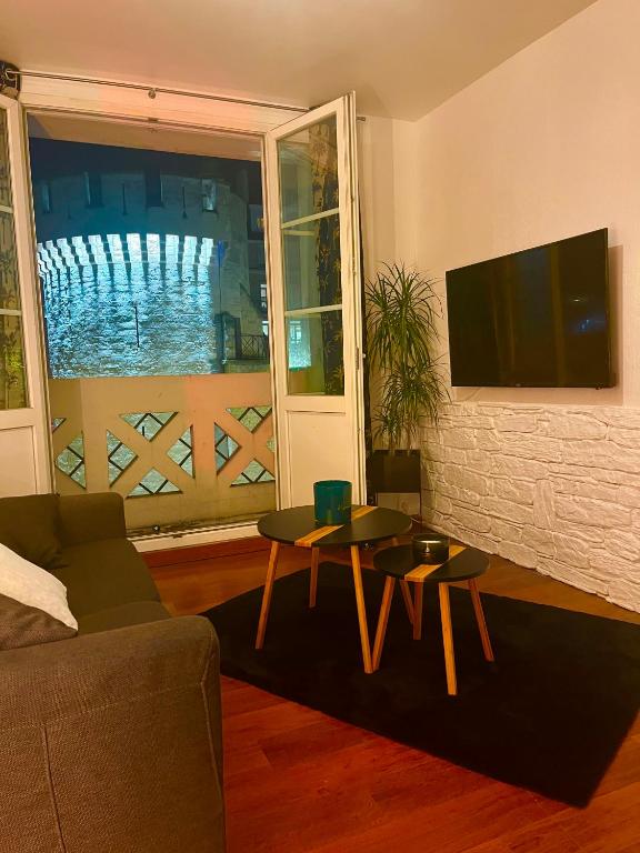 a living room with a couch and a table at Escapade jacuzzi in Caen