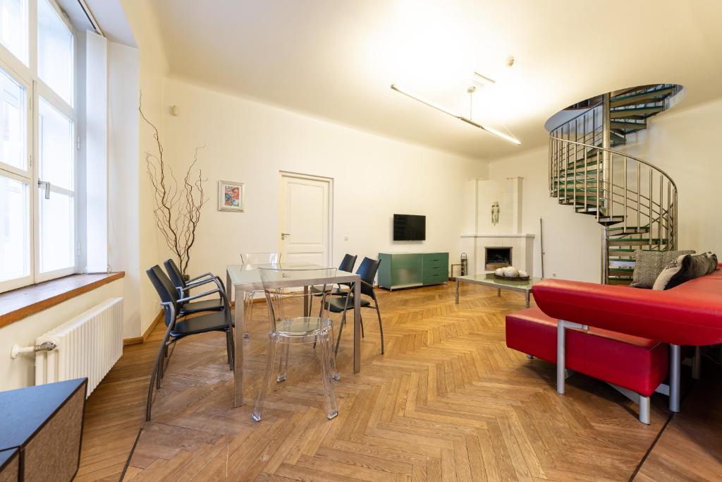 ein Wohnzimmer mit einem Tisch und Stühlen sowie einer Wendeltreppe in der Unterkunft Old Town - Vene Apartment in Tallinn