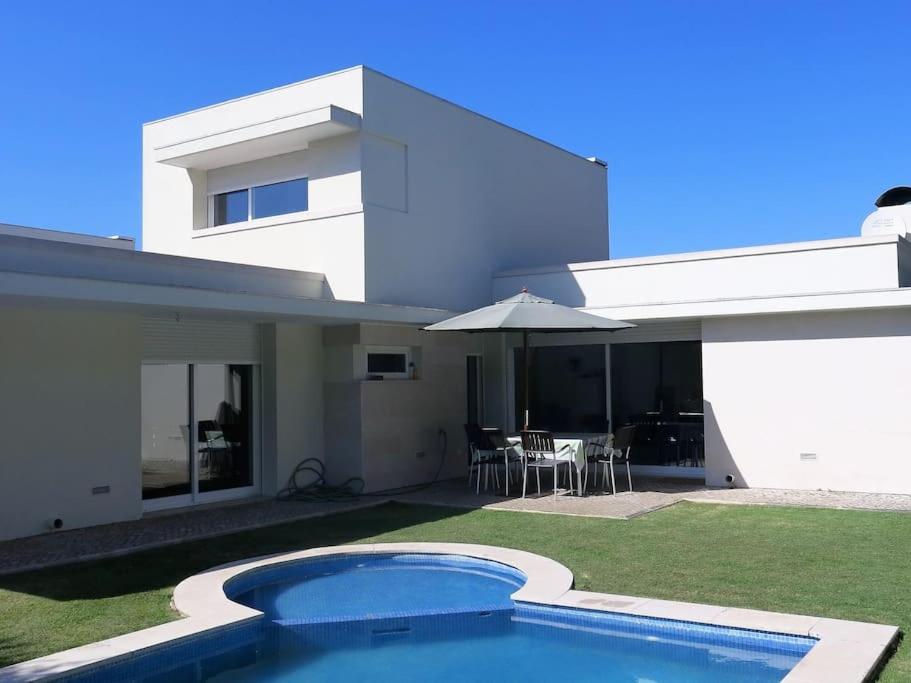 a house with a swimming pool in front of it at Sea wave sounds, Meco, by the beach in Sesimbra