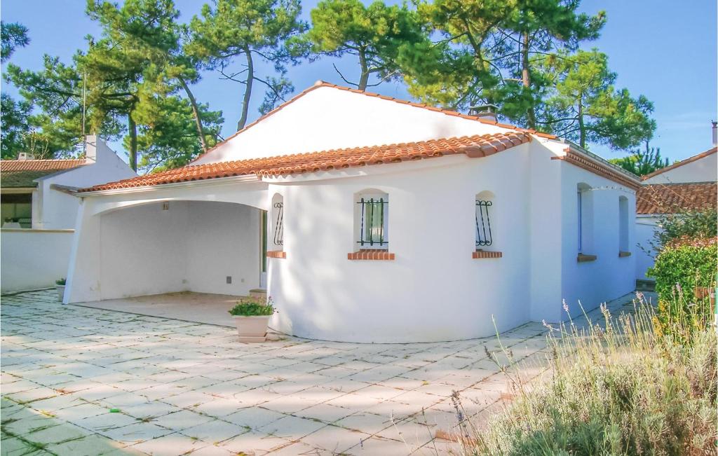 une maison blanche avec une cour dans l'établissement Three-Bedroom Holiday Home In La Tranche Sur Mer, à La Tranche-sur-Mer