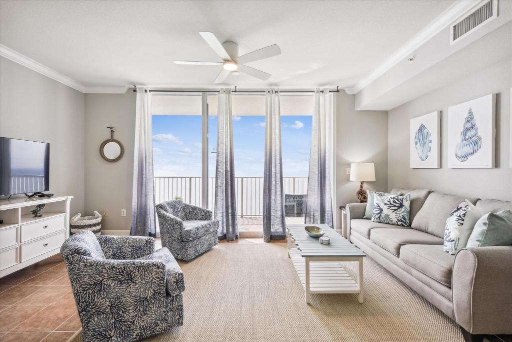 a living room with a couch and chairs and a large window at Gone Coastal - Tidewater Beach Resort #2410 by Book That Condo in Panama City Beach