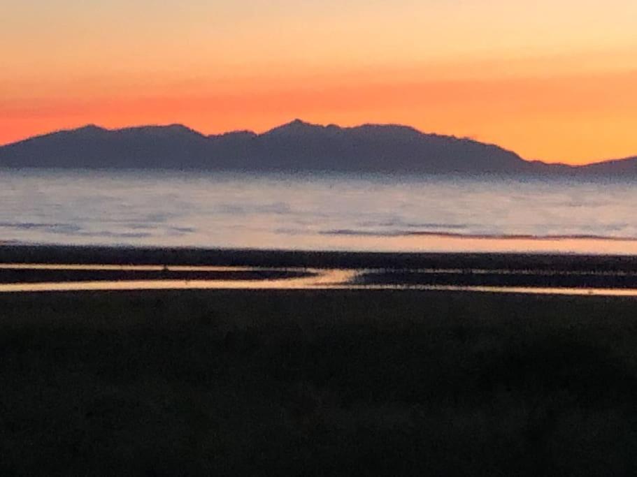 een zonsondergang over de oceaan met bergen op de achtergrond bij Best location in town, it is all on the doorstep. in Ayr