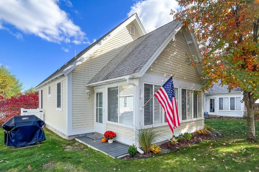 une petite maison arborant un drapeau américain dans l'établissement Cottage Retreat, à Wells
