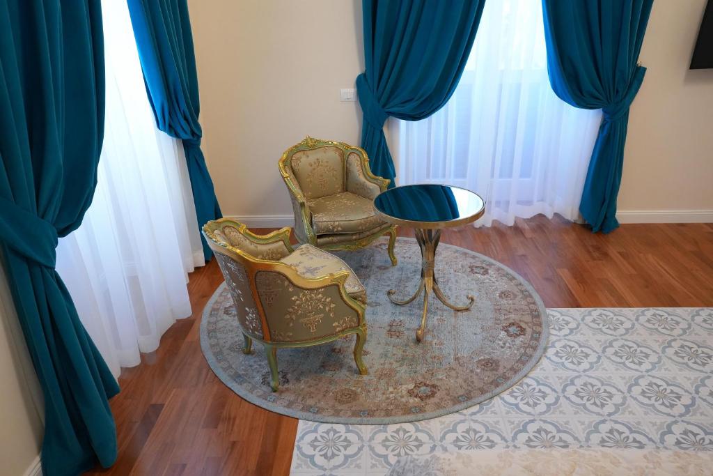 - 2 chaises et une table dans une chambre dotée de rideaux bleus dans l'établissement Rosetta Burger Queen, à Cagliari