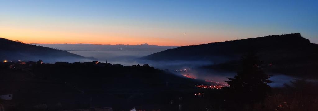 a view of a foggy mountain at sunset at La maison py in Vergisson