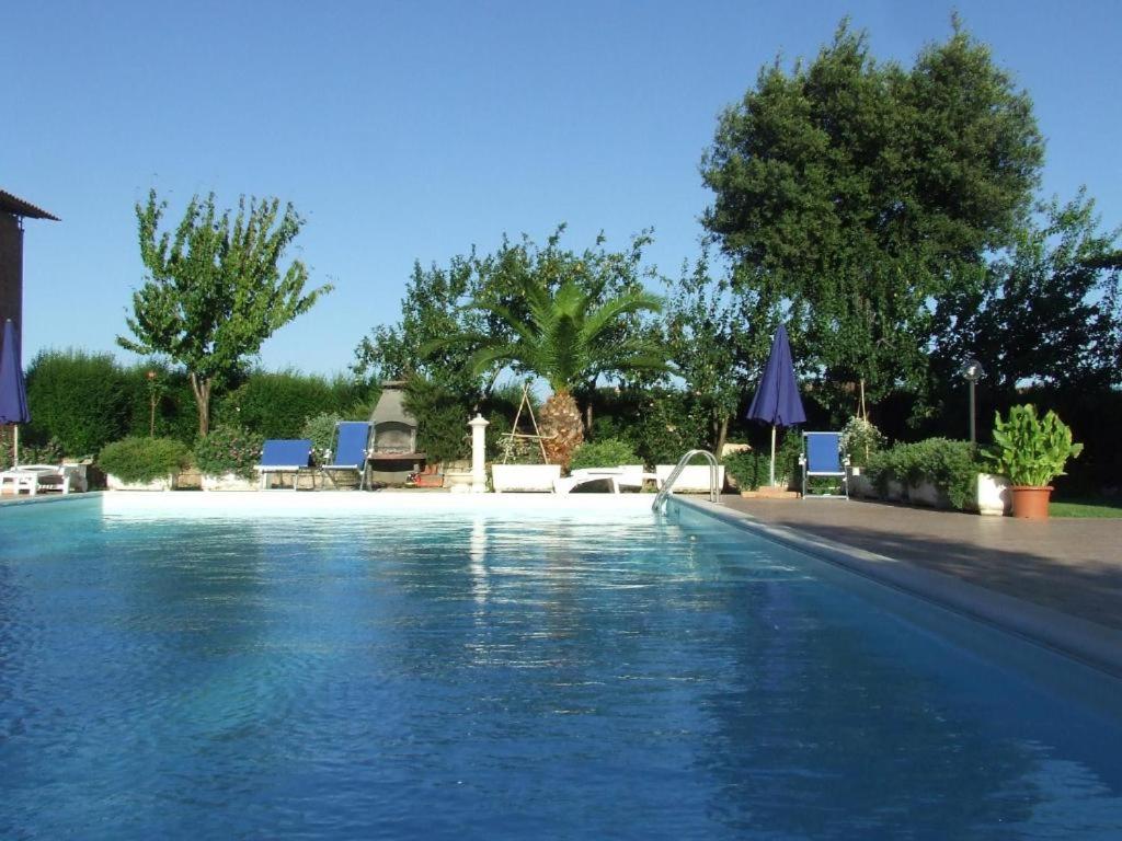 a swimming pool with chairs and umbrellas at Il Punto Verde in SantʼAntonio