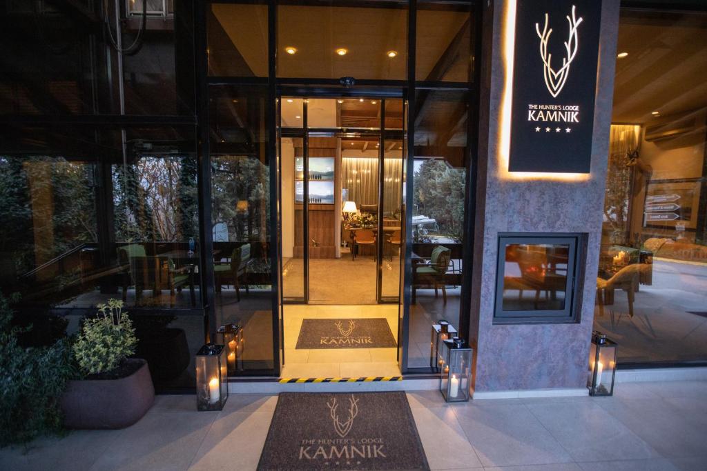 een toegang tot een restaurant met een bord met karma bij The Hunter's Lodge Kamnik in Skopje