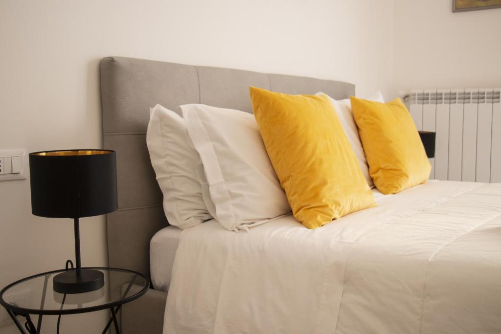 a bed with two yellow pillows on top of it at Aragona15 Suites in Palermo