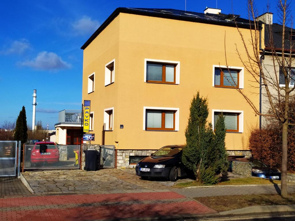 a car parked in front of a yellow building at Ubytování Velký Týnec 376 in Velký Týnec