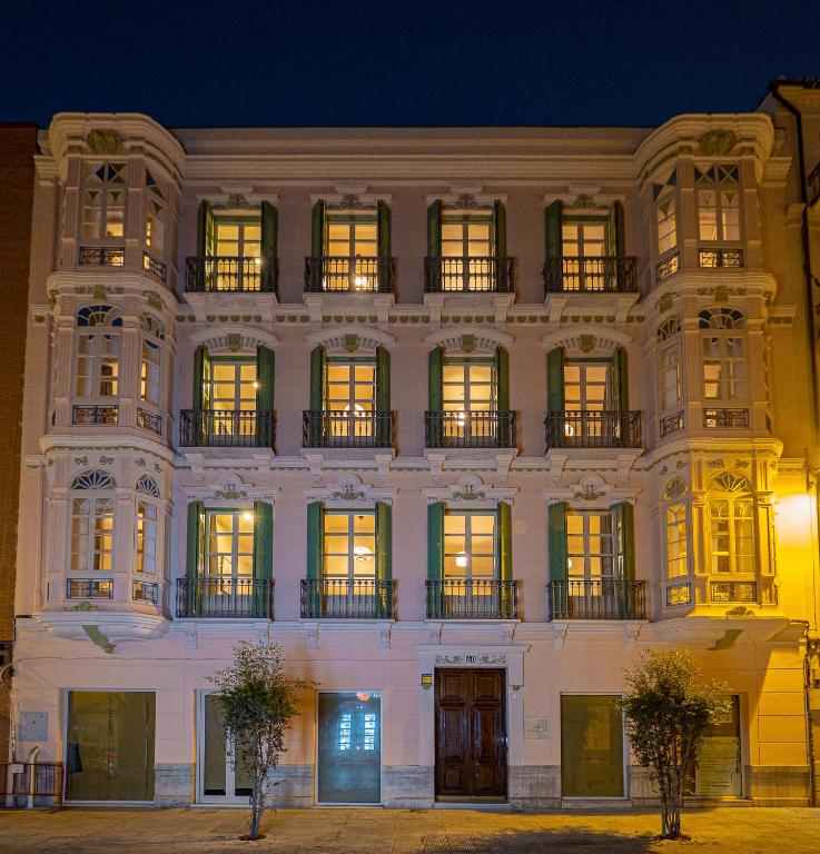duży biały budynek z oknami w nocy w obiekcie Elegante 3 dormitorios en Centro Historico Málaga w Maladze