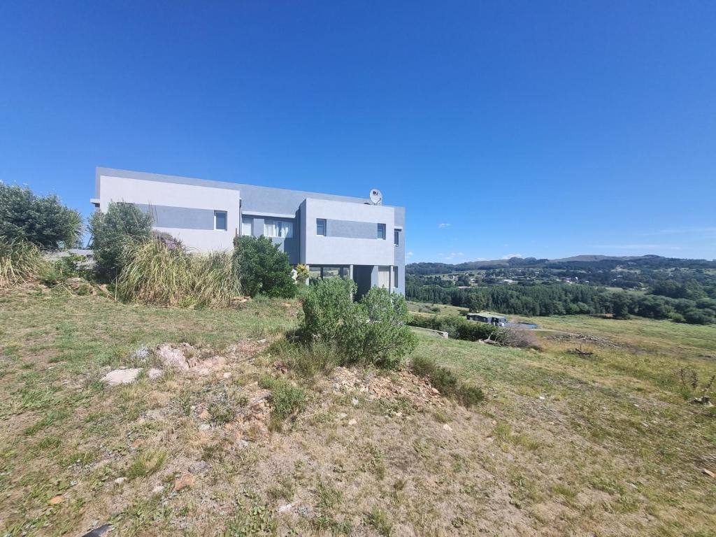 una casa blanca en la cima de una colina en La Casa de los Vientos en Tandil