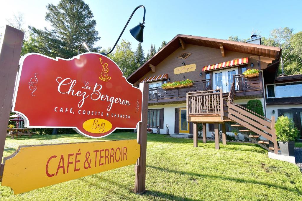 um sinal para o Café Cityleigh e Herrer em frente a uma casa em Chez Les Bergeron em Saint Aime Des Lacs