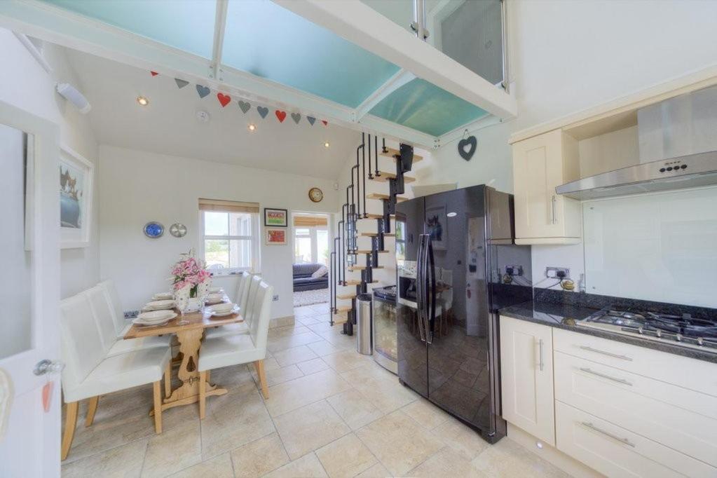 a kitchen with a table and a dining room at Pen Y Sarn in Abersoch