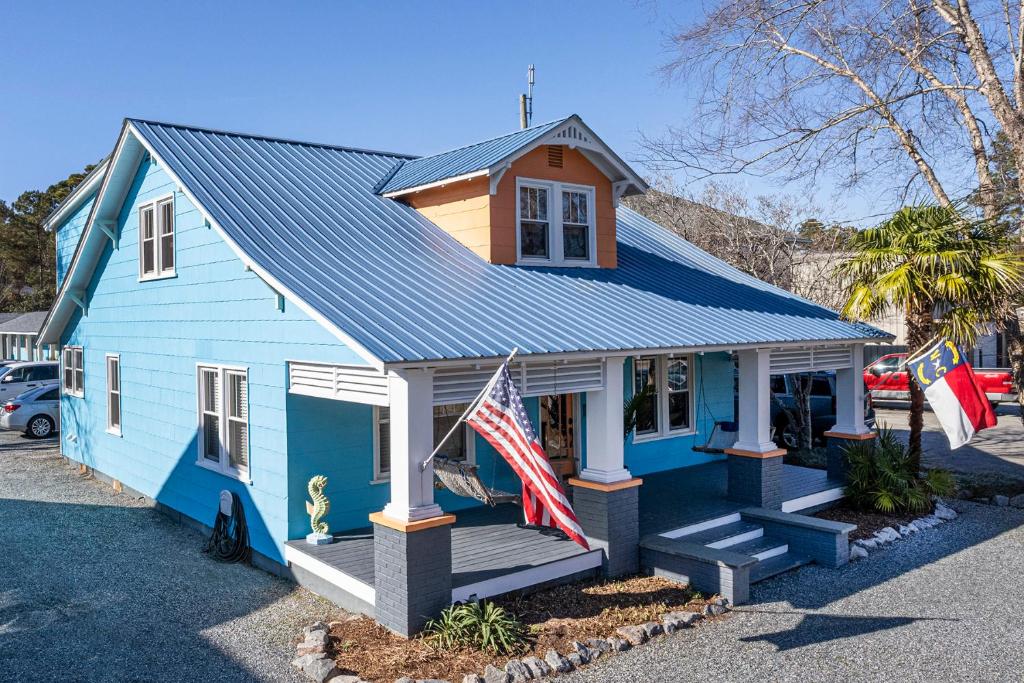 Uma casa azul com uma bandeira americana à frente. em Island Motel OBX em Manteo