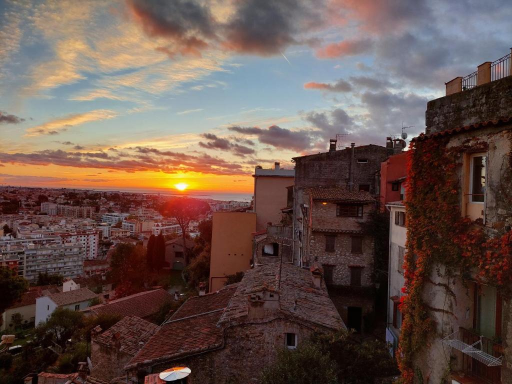 uma vista para o pôr-do-sol a partir de um edifício em Maison de village Haut-de-Cagnes avec vue mer em Cagnes-sur-Mer