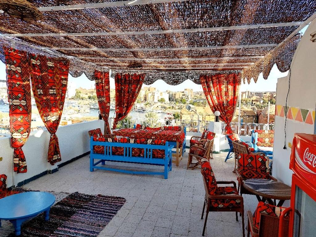 a restaurant with red chairs and tables and a view at Gamal Robob Nubian Guest House in Aswan