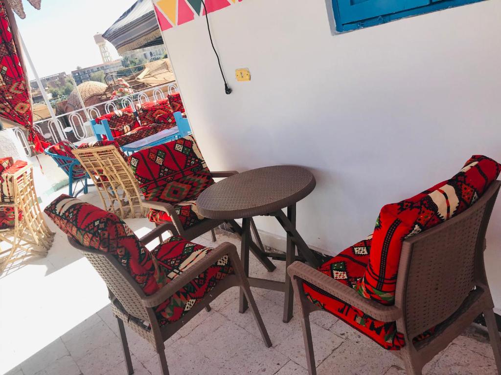 a table and chairs in a room with a window at Gamal Robob Nubian Guest House in Aswan