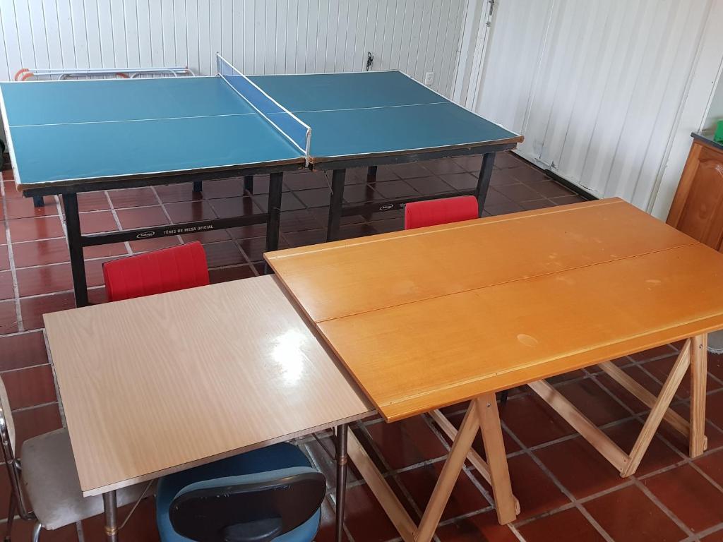 two tables and chairs with a ping pong table at Casa Aurora in Cambara do Sul