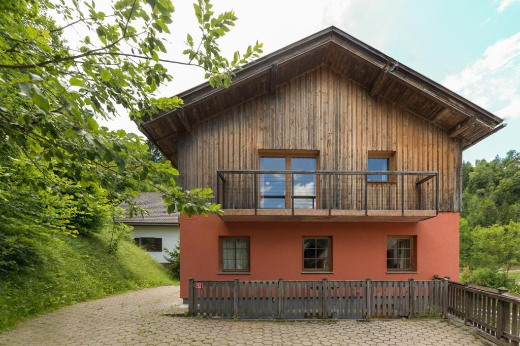 a house with a balcony on the side of it at The Red House in Spodnje Gorje