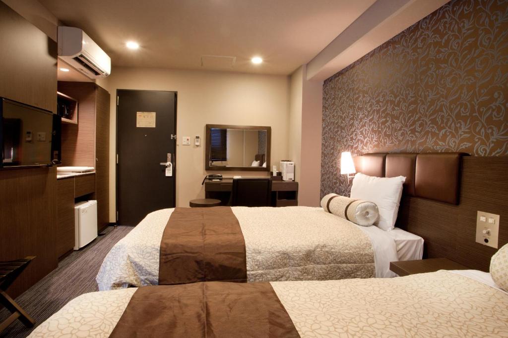 Kuretake Inn Premium Shizuoka Ekimae tesisinde bir odada yatak veya yataklar