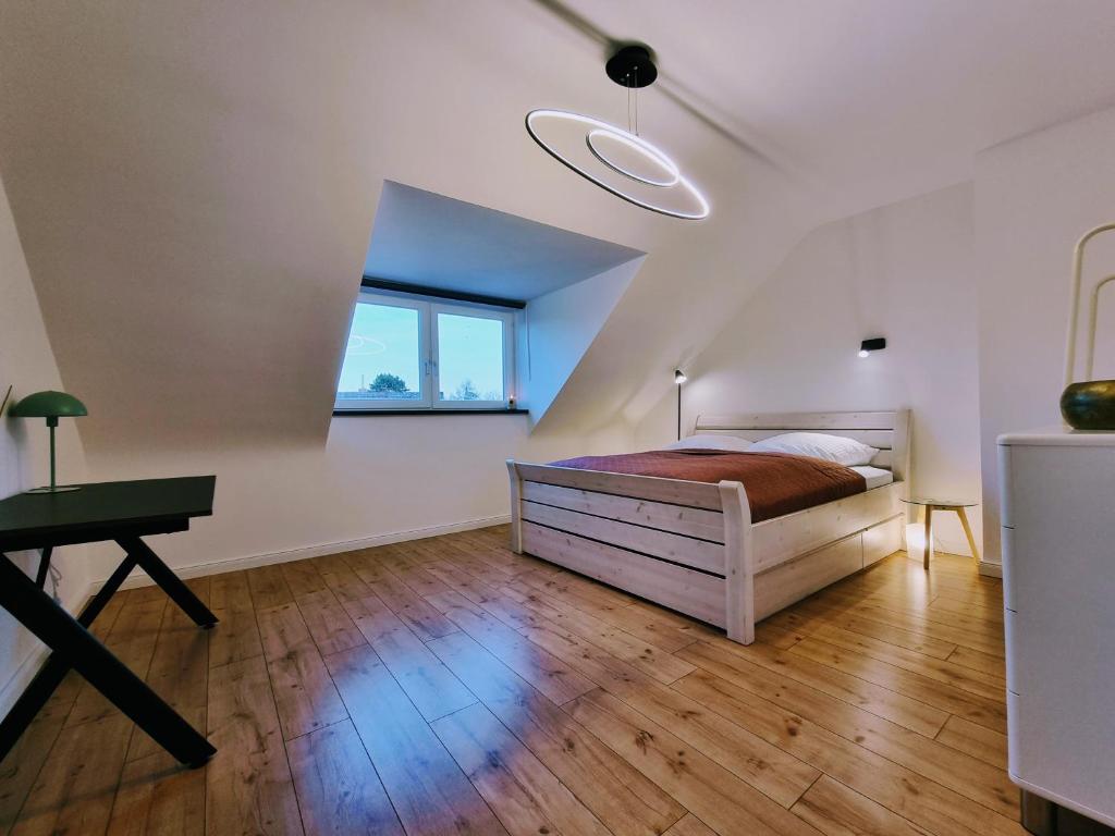 1 dormitorio con cama, escritorio y ventana en Hell & ruhig, 200m zur U-Bahn, en Ahrensburg