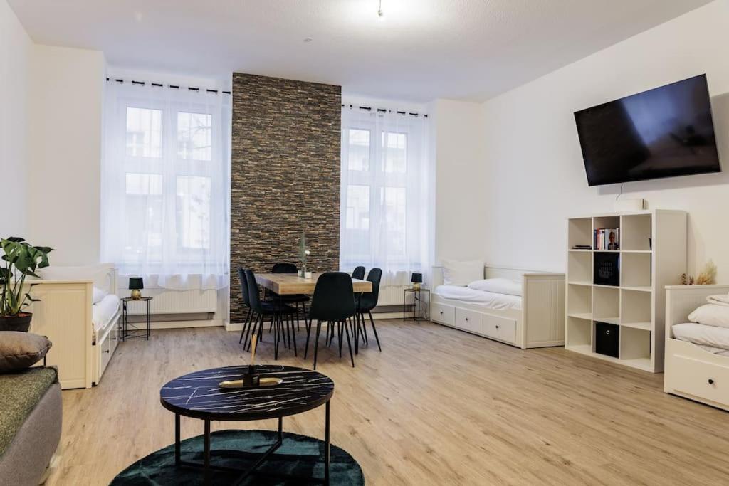 een woonkamer met een tafel en stoelen en een bank bij DR Apartments Boxhagener Kiez in Berlijn