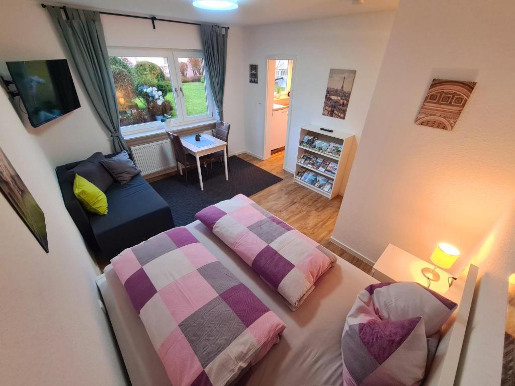 een slaapkamer met 2 bedden, een bank en een raam bij Apartment Salinenpromenade Bad Kissingen in Bad Kissingen