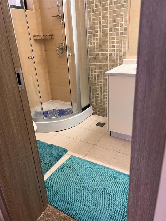 La salle de bains est pourvue d'une douche et de 2 tapis turquoise. dans l'établissement Crestpark 3br furnished apt, à Nairobi
