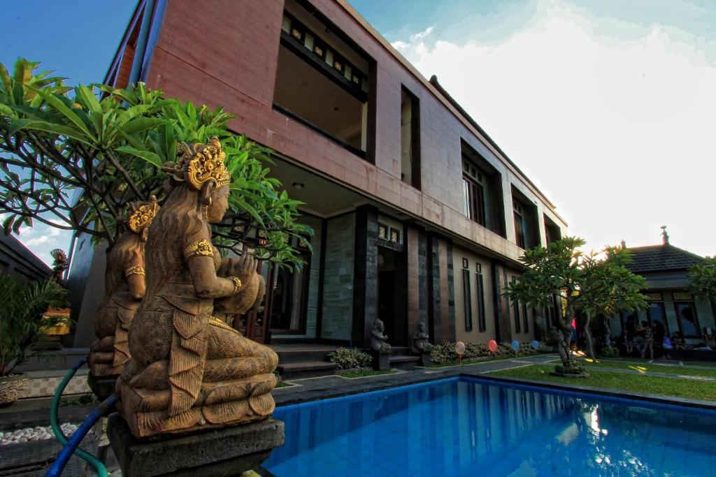 una estatua de dos mujeres de pie junto a una piscina en Ubud Canti Accommodation, en Ubud