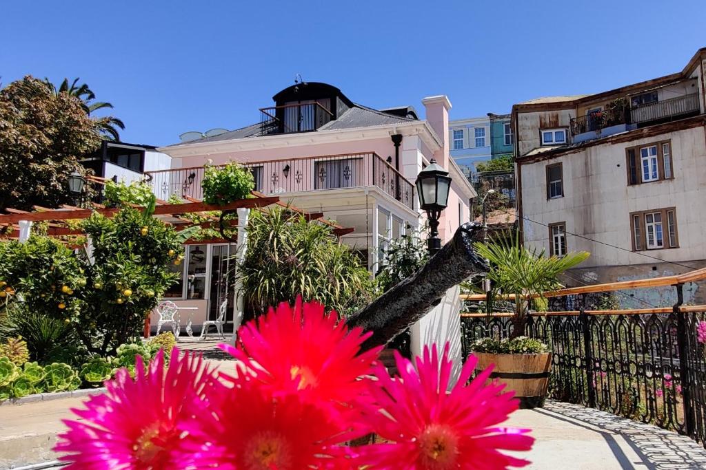 a group of pink flowers in front of a house at AYCA La Flora Hotel Boutique in Valparaíso