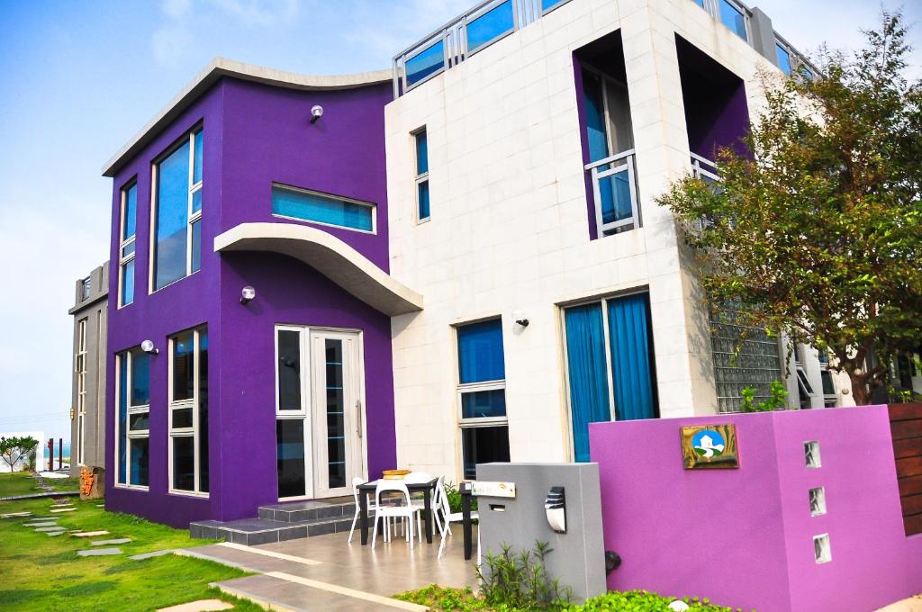 a purple and white house with a table in front of it at Hai Pu B&B in Magong