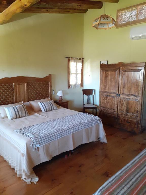 a bedroom with a large bed and a wooden floor at Posada Almazen in Las Compuertas